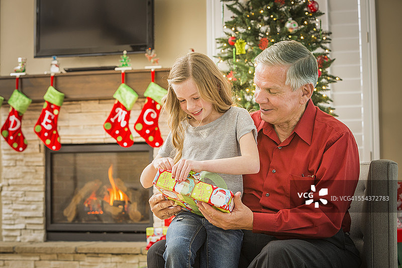 白人爷爷和孙女一起打开圣诞礼物图片素材