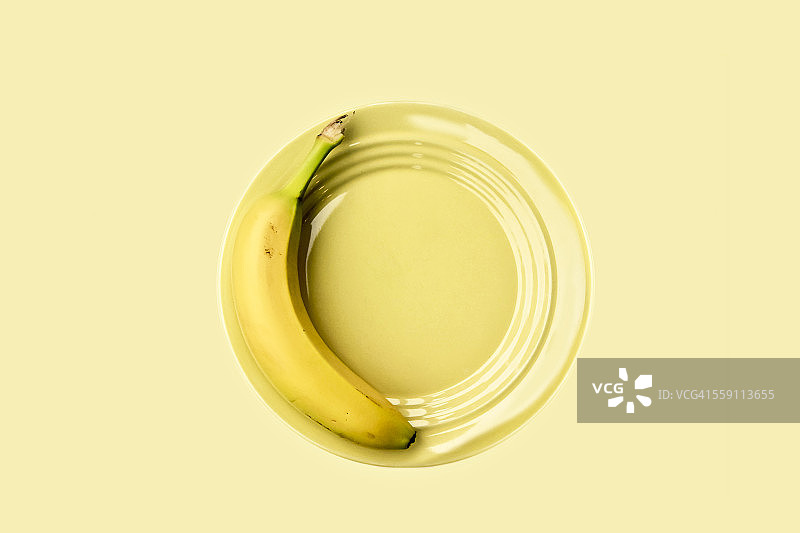 黄色的香蕉放在黄色的盘子里图片素材