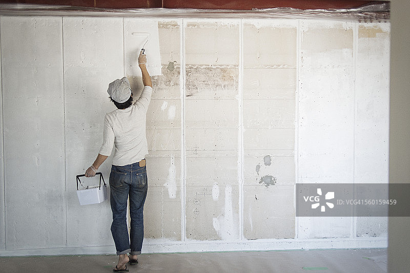 男人用滚筒刷刷墙图片素材