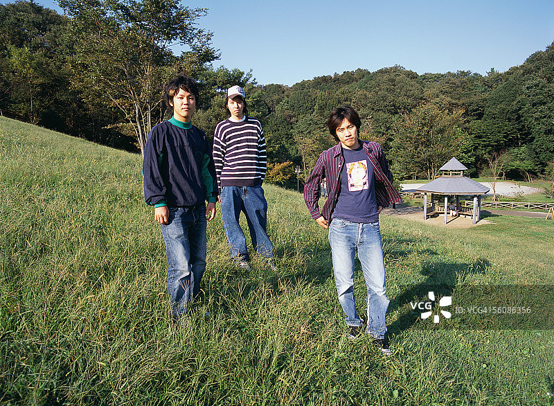 三个年轻人站在田野里图片素材