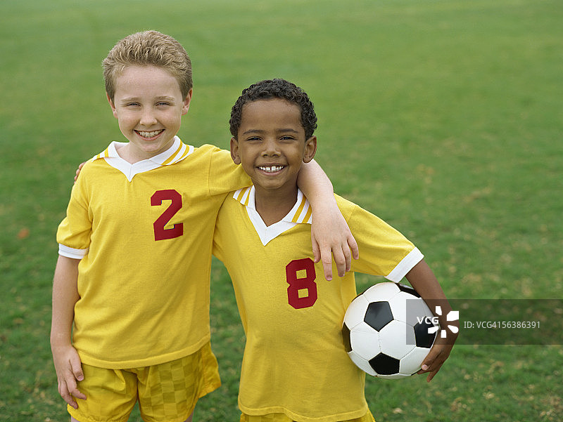 两个男孩的肖像站在一个足球在一个领域图片素材