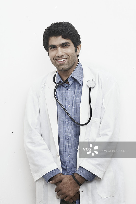 一名男医生脖子上挂着听诊器站在那里图片素材