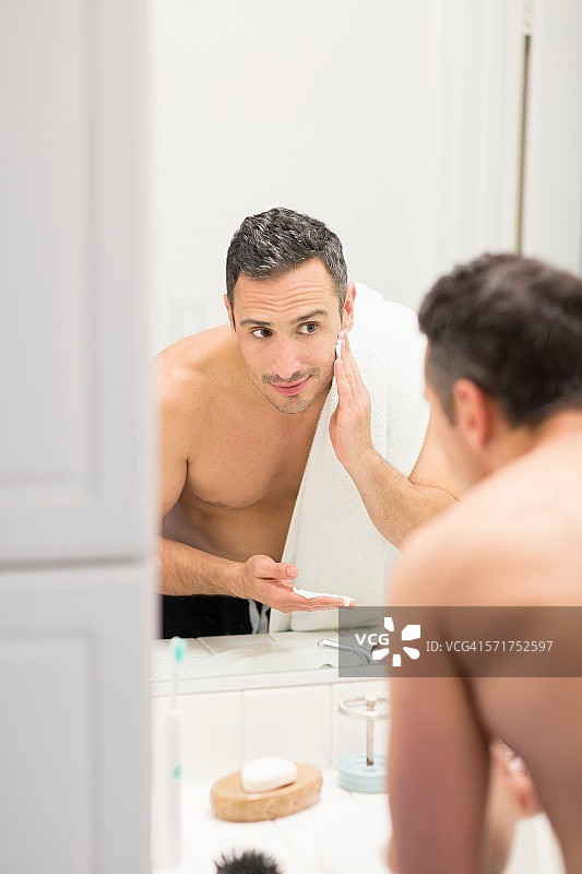 中年男子，照镜子，往脸上抹剃须泡沫，后视镜图片素材