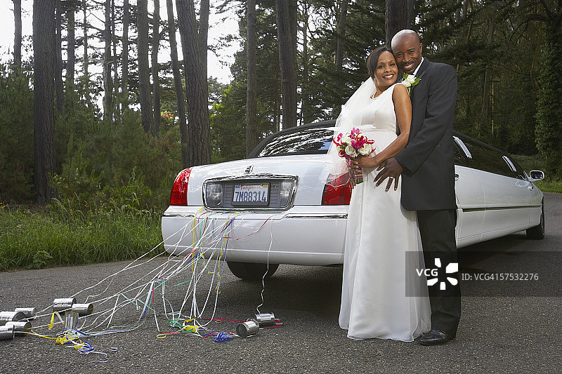 一对新婚夫妇在车旁拥抱图片素材