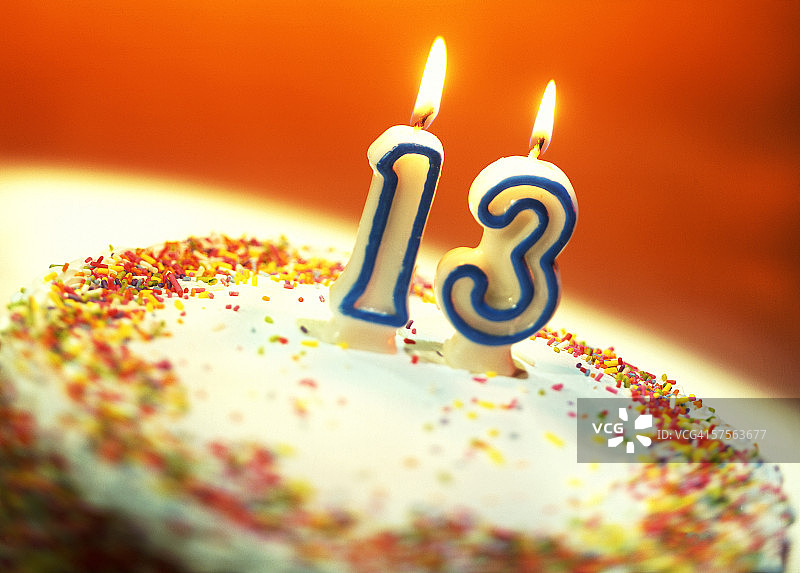 一个生日蛋糕的特写，上面有一根13号蜡烛图片素材