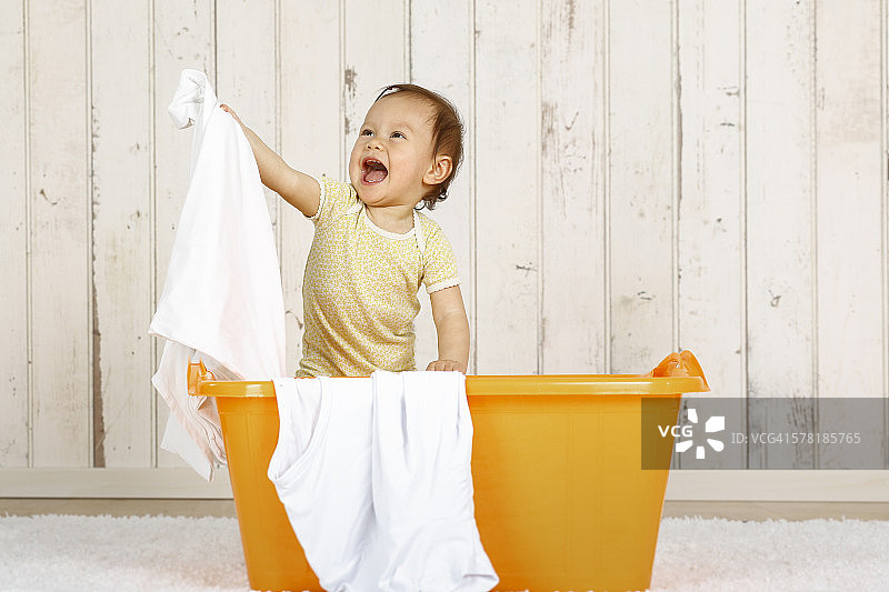 小女孩站在洗衣篮里图片素材