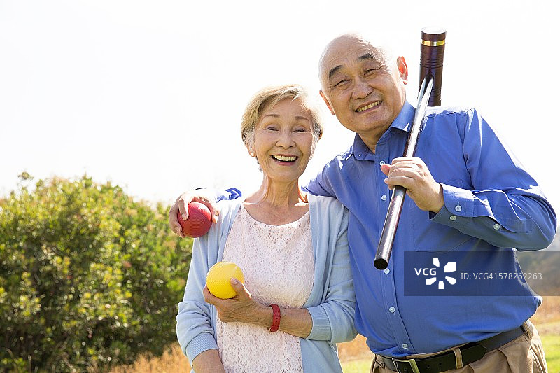 公园里一对老年夫妇的肖像，拿着槌球锤和球图片素材