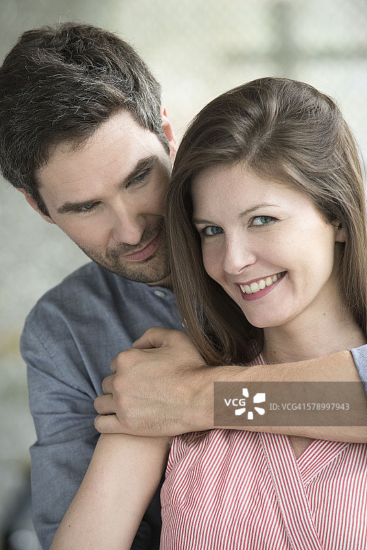 女人微笑着，丈夫拥抱着她，肖像图片素材