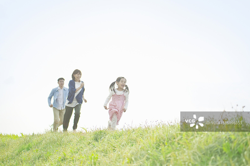 年轻的家庭在山上奔跑图片素材