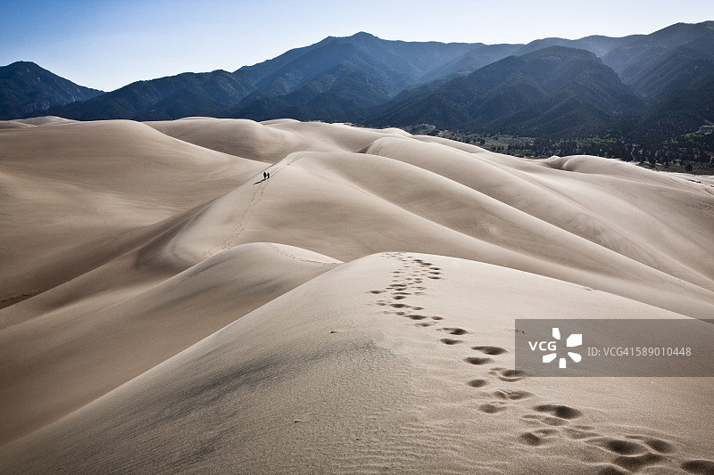 美国科罗拉多州沙丘上留下脚印的两个人图片素材