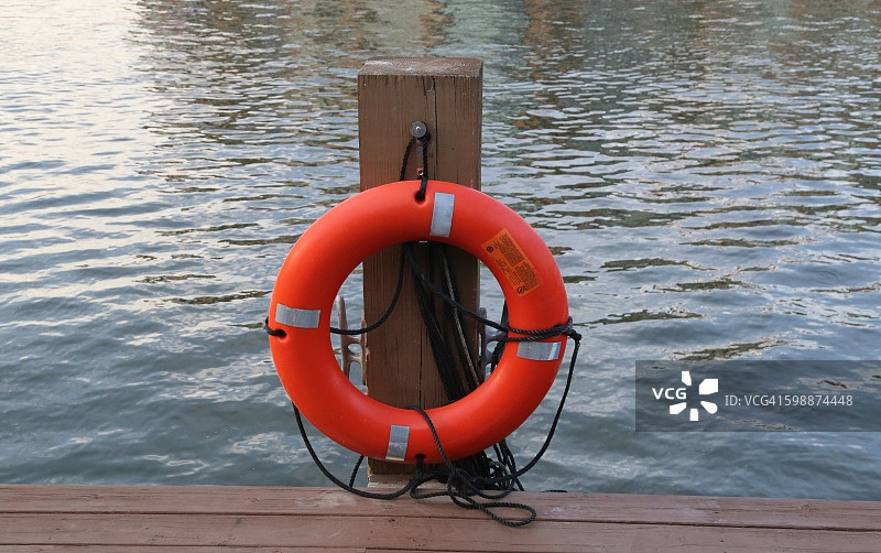 橙色救援漂浮设备靠近木板路图片素材