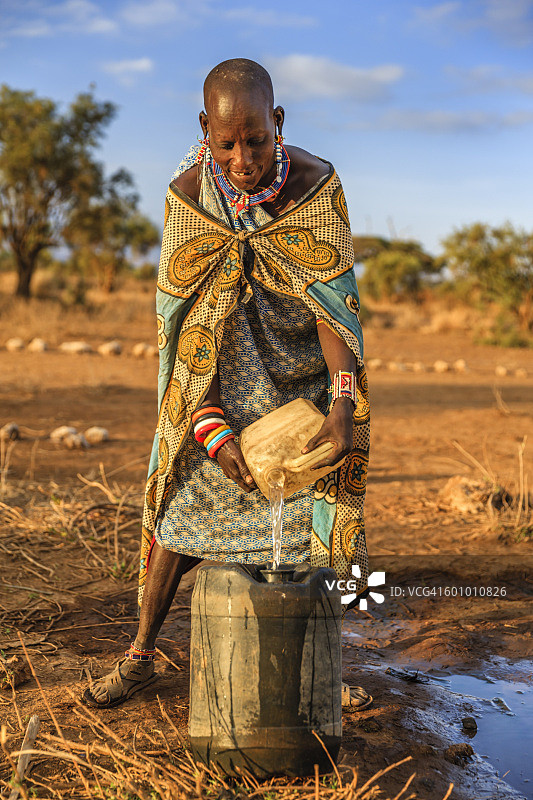 来自马赛部落的非洲妇女在收集水，肯尼亚，东非图片素材