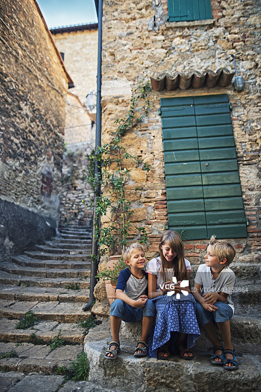 在意大利的一个小镇上，孩子们正在使用智能手机图片素材