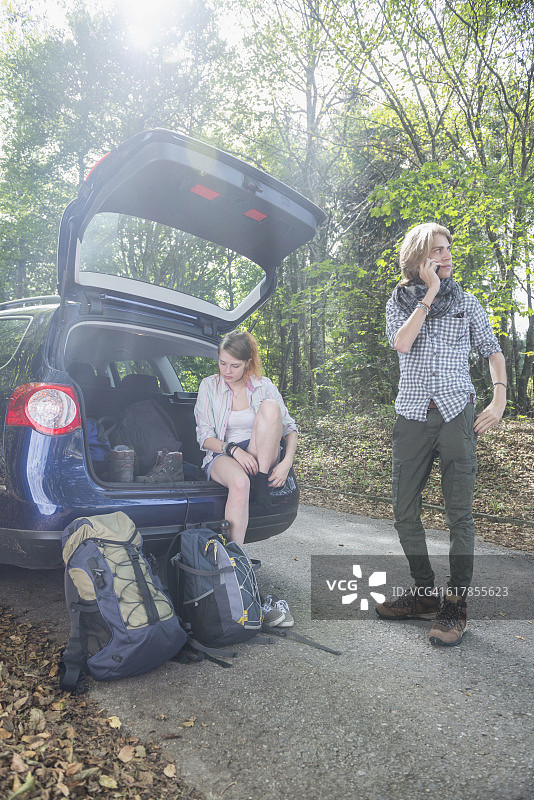 “德国巴伐利亚，一对年轻夫妇准备在森林里徒步旅行”图片素材