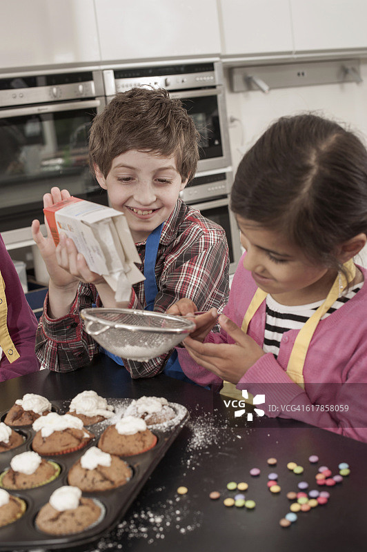 “德国巴伐利亚，学生在家政课上往松饼上撒糖粉”图片素材