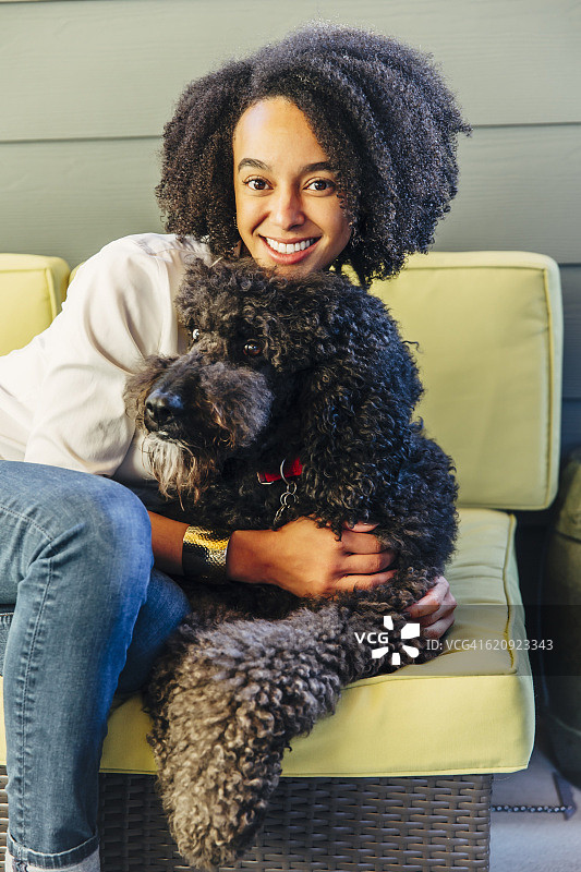 混血妇女拥抱狗在沙发上图片素材