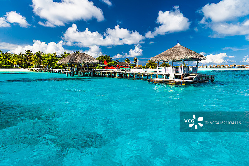 完美的热带岛屿，天堂般的海滩马尔代夫。长长的码头和一艘传统的小船。图片素材