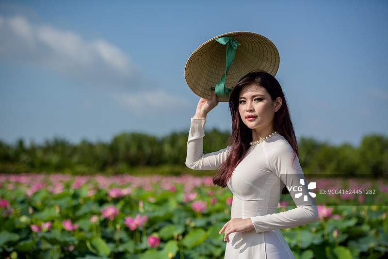 越南女子穿着傲黛(长裙)在莲花池图片素材
