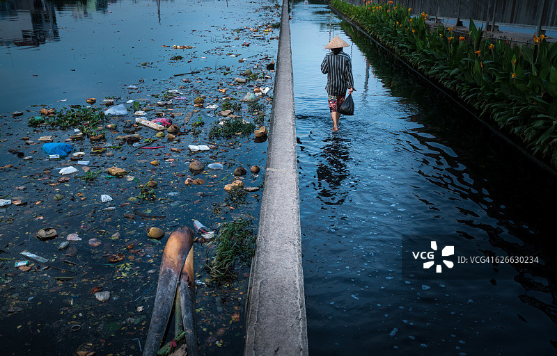 胡志明市河滨区8区在涨潮日，区内到处是垃圾、垃圾，环境污染严重图片素材