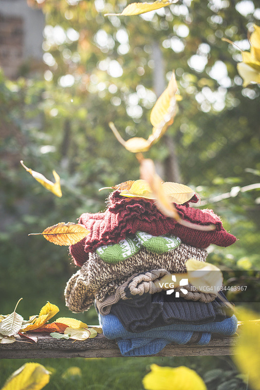 一堆暖和的衣服和飘落的秋叶图片素材