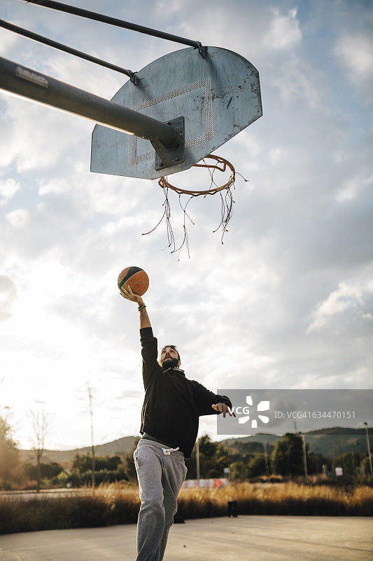 一个年轻人在室外打篮球图片素材