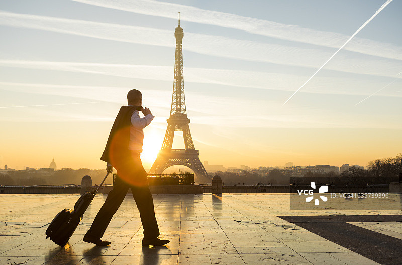 旅行家提着旅行箱走在巴黎埃菲尔铁塔上图片素材