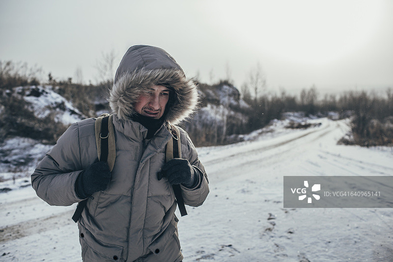 徒步旅行者背着背包，站在积雪覆盖的景观上图片素材