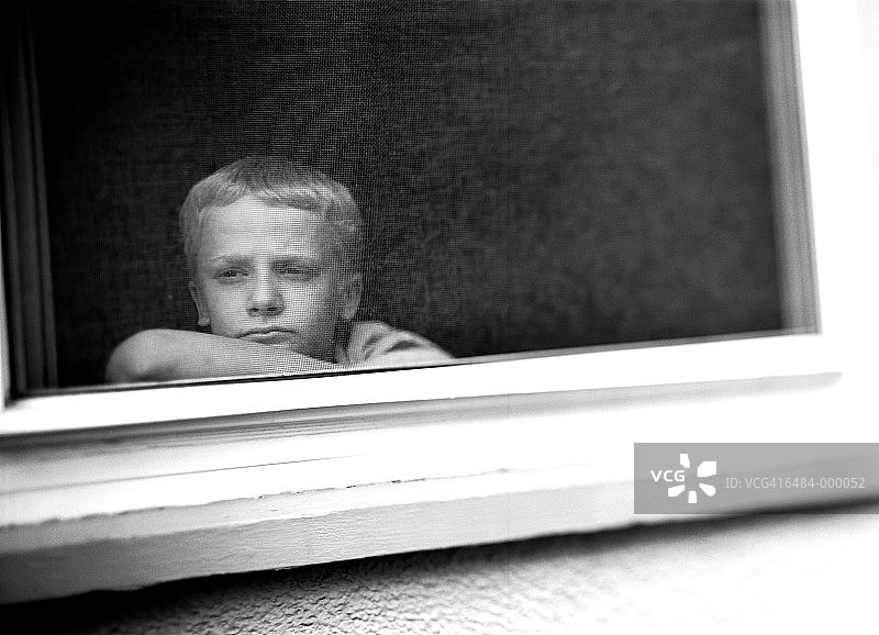 男孩盯着窗外图片素材