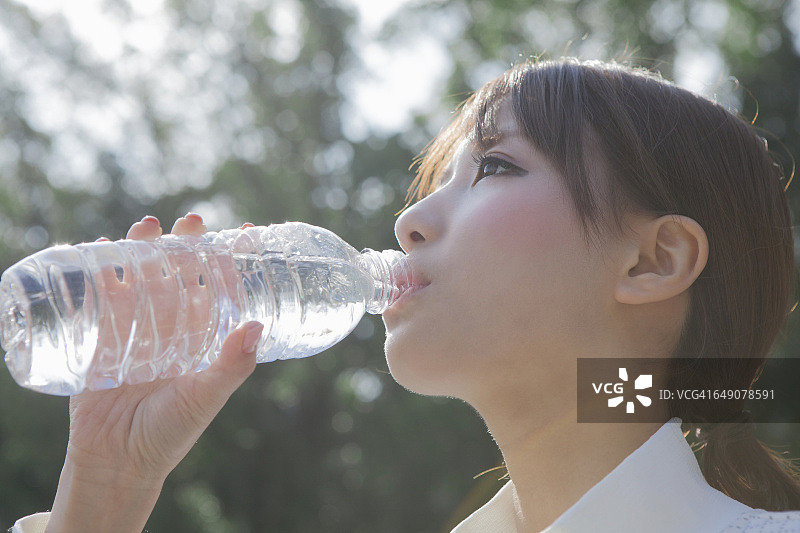 喝公园里水的日本女人图片素材