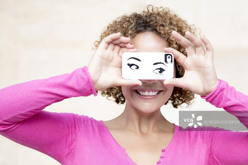 微笑的马达加斯加妇女的特写镜头与手机在眼前图片素材