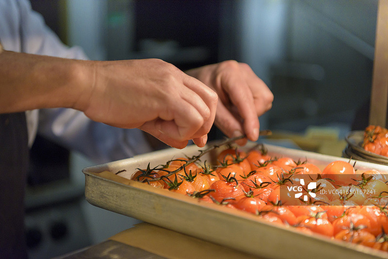 厨师在传统的意大利餐厅厨房里准备西红柿，特写图片素材