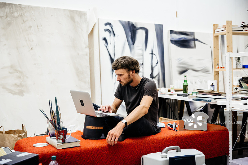 艺术家在他的工作室里使用笔记本电脑图片素材