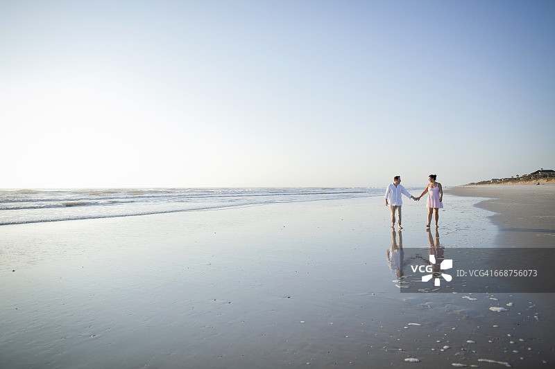 一对情侣在海滩上散步图片素材