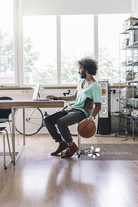 一个年轻人在办公室打篮球图片素材