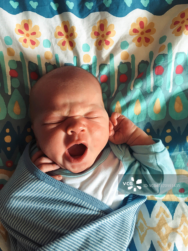 婴儿从睡眠中醒来时打哈欠图片素材
