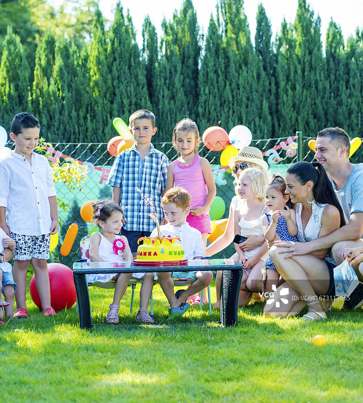 孩子们与朋友和家人在花园里庆祝生日聚会图片素材