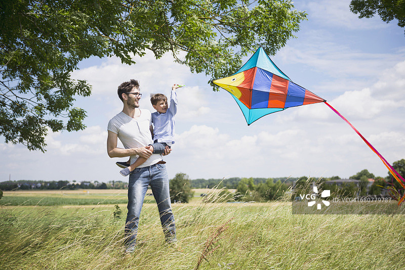 德国巴伐利亚，父亲和儿子在乡下放风筝图片素材