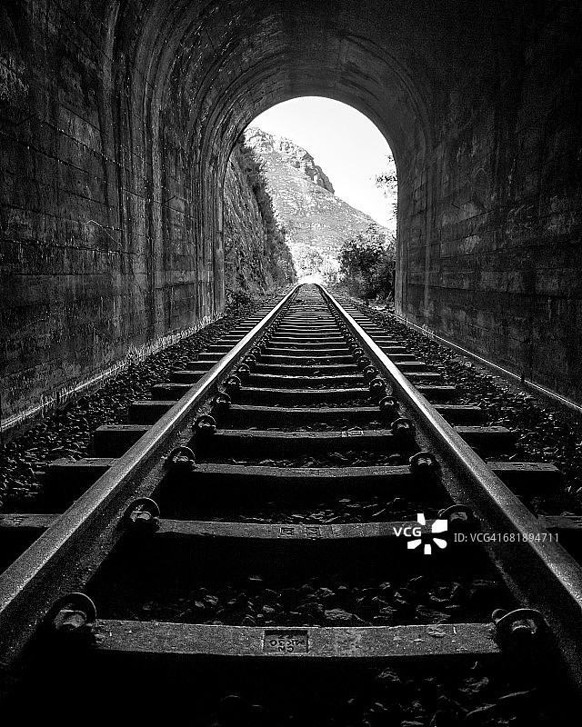 火车轨道从乌特尼夸山脉的隧道通往南非西开普的乔治。图片素材