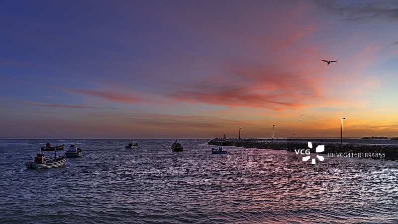 斯特鲁伊斯拜渔港的日出给云朵抹上了粉红色。停泊的渔船图片素材
