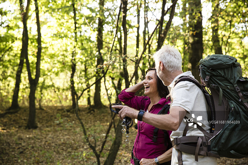 一对快乐的老年夫妇在森林里徒步旅行图片素材