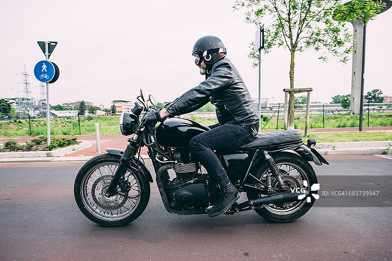 男性摩托车手在公路上骑摩托车图片素材