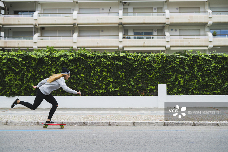 年轻女子在街上玩滑板图片素材