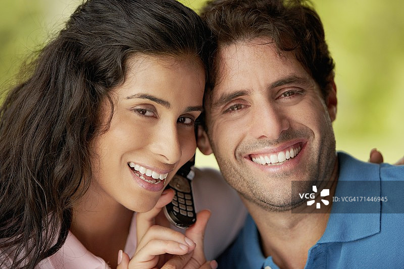 一个中年男人和一个年轻女人拿着手机的肖像图片素材