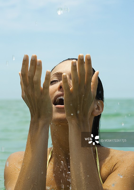 女人在水里扑打着水，闭着眼睛图片素材