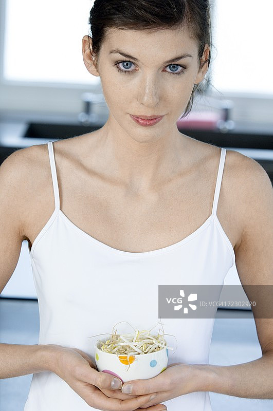 年轻女子端着一碗豆芽图片素材