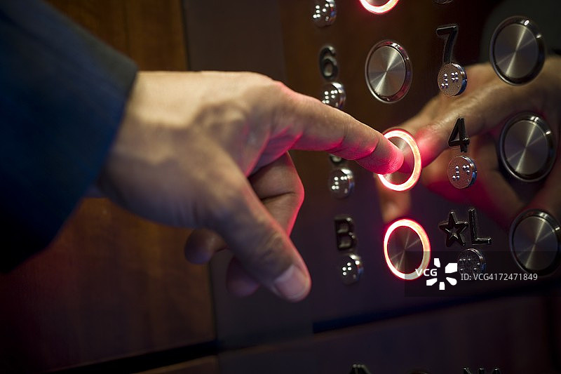 一个人的手指按电梯按钮的特写图片素材