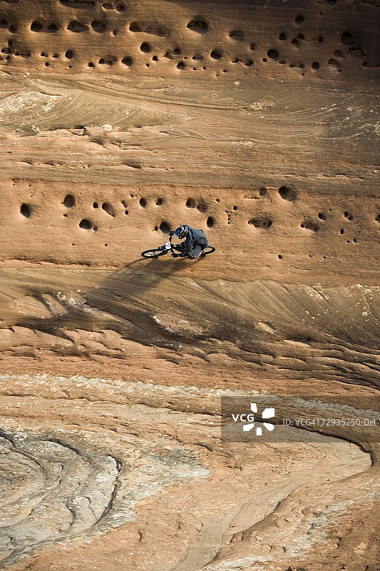 在犹他州摩押的垂直墙上骑山地自行车的人。图片素材