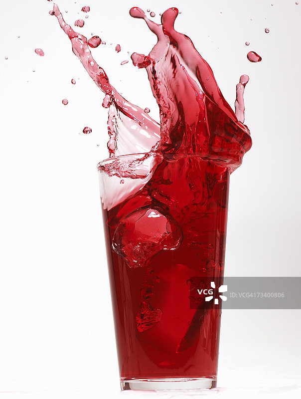 红汁从玻璃杯里溢出来图片素材