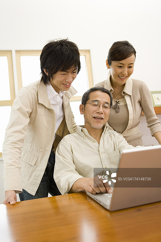 一个家庭一起使用笔记本电脑，前视图，侧视图图片素材