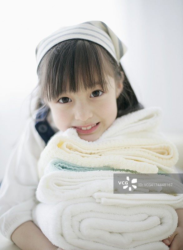 日本女孩微笑着接受架子上的毛巾图片素材